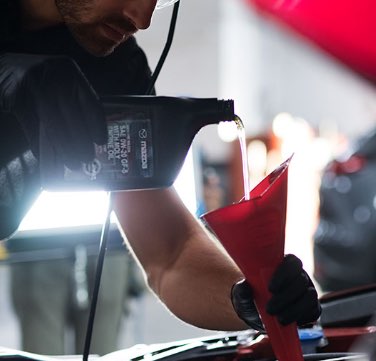 Technician pouring Oil